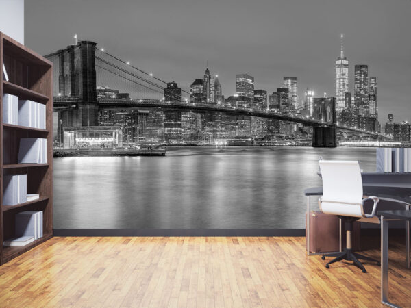 Panoramic view of Brooklyn Bridge and Lower Manhattan skyline in New York City at night with city illumination, USA. Black and white toned